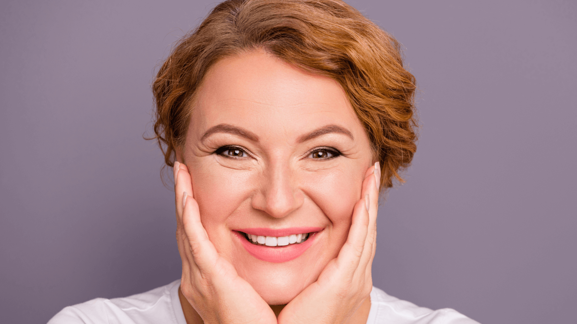 woman holding her face and smi